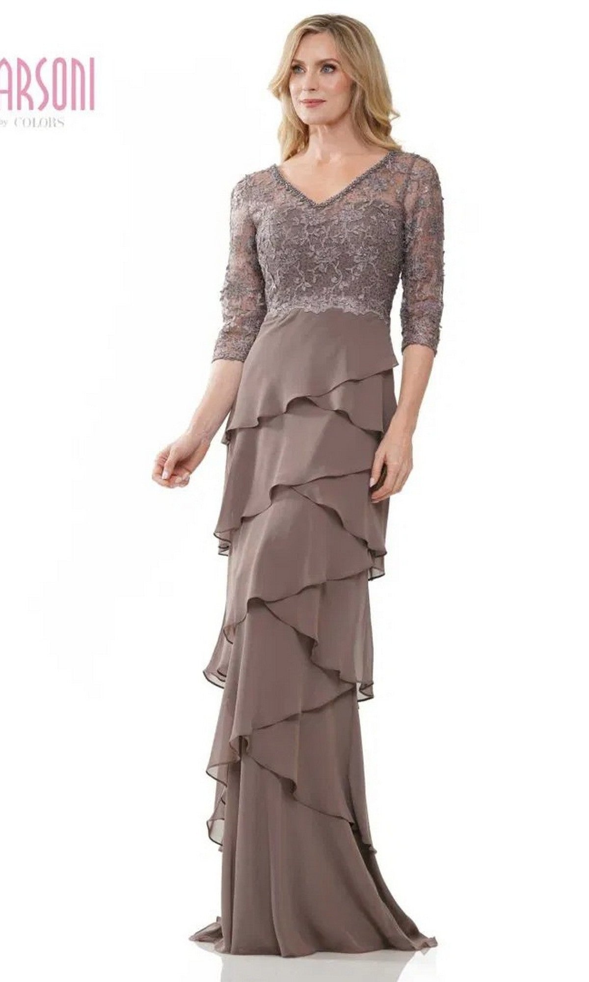 A woman stands against a white background wearing the Marsoni MV1244 long formal dress in taupe, featuring lace sleeves, a lace embroidered bodice, and a tiered ruffled chiffon column skirt.